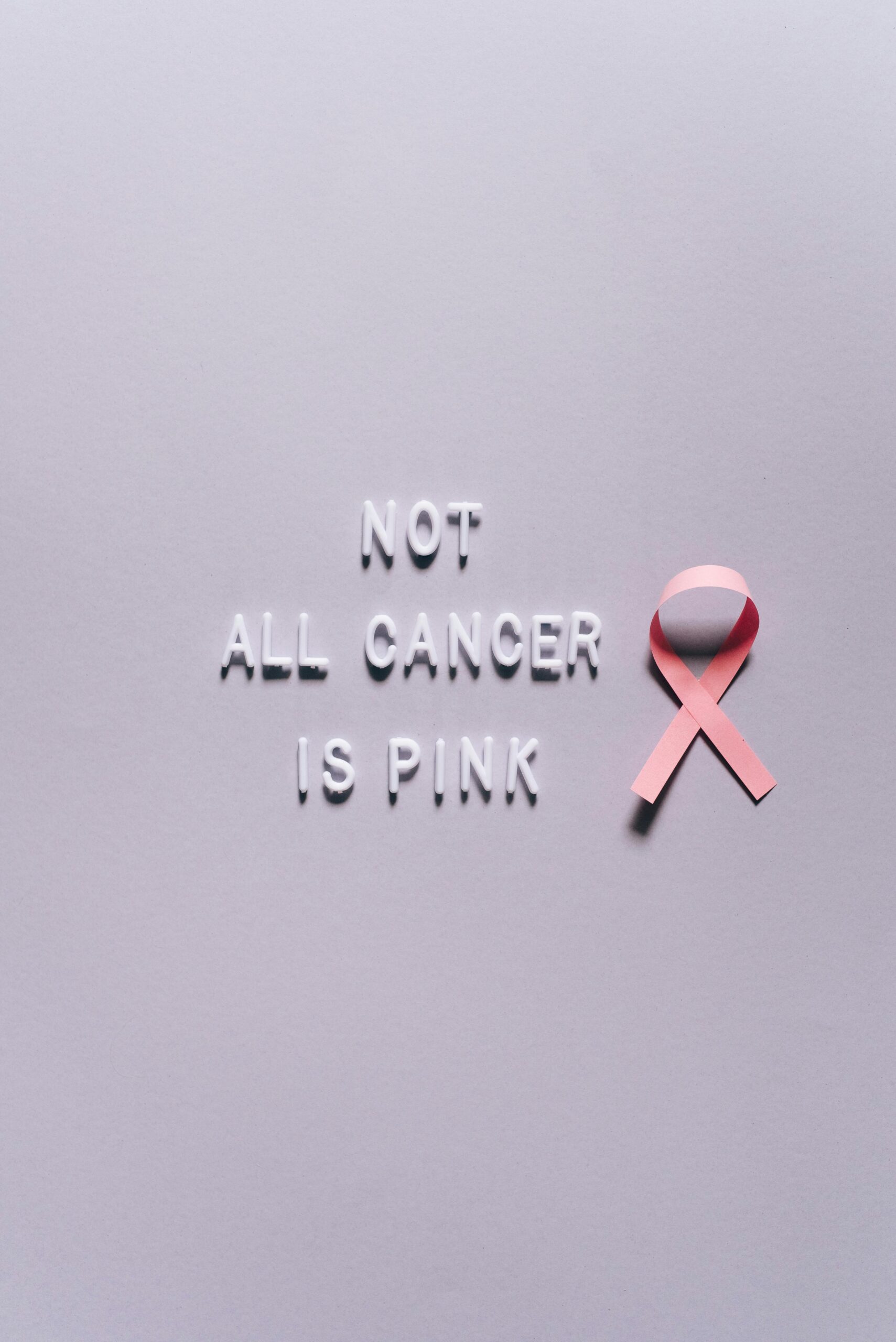 Conceptual image symbolizing cancer awareness with pink ribbon and text.