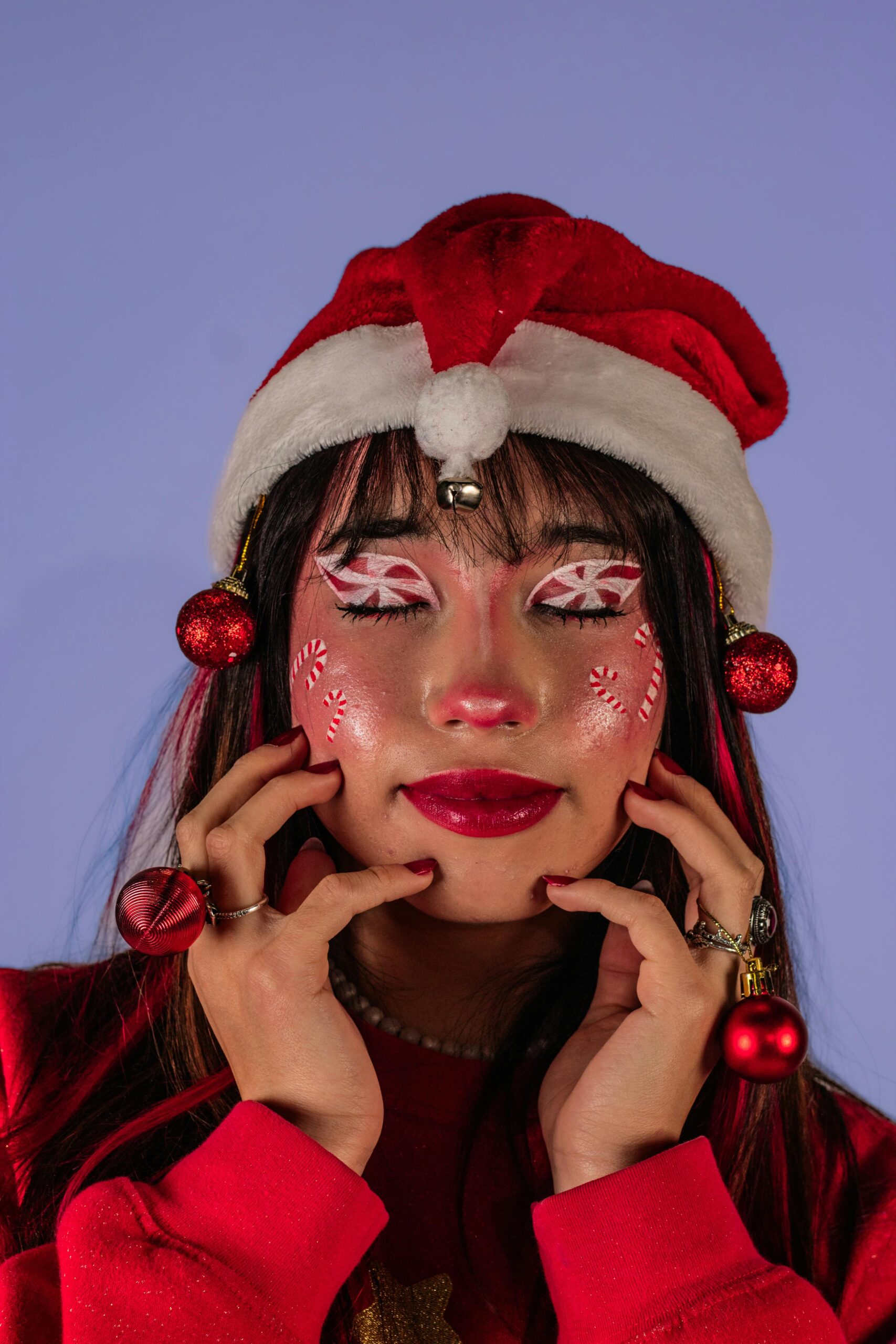 Woman with festive makeup and Santa hat celebrating Christmas.