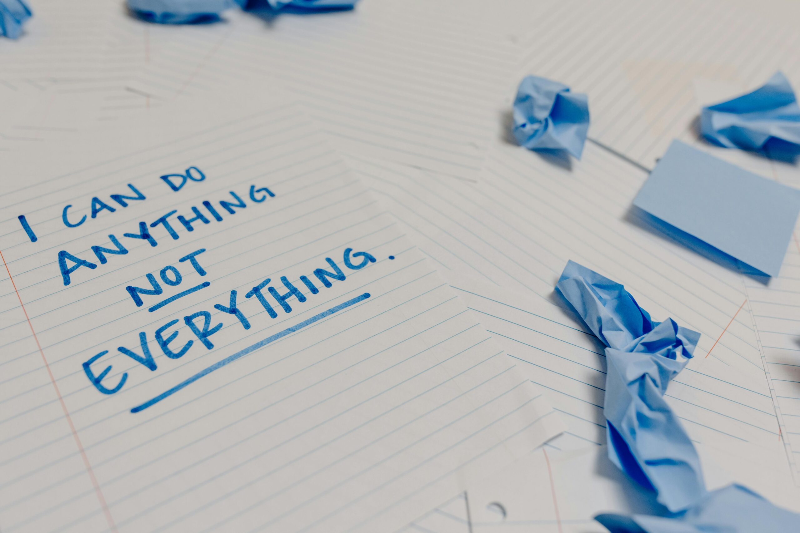 Motivational message on a page surrounded by crumpled papers and blue sticky notes.